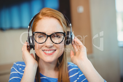 Female graphic designer listening music on headphones