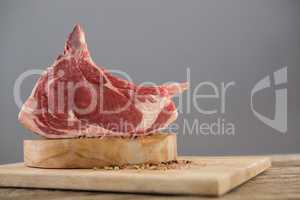 Beef ribs rack and spices on wooden tray against wooden background