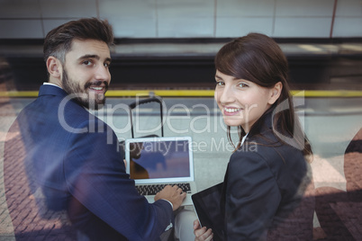 Business executives using digital tablet on platform