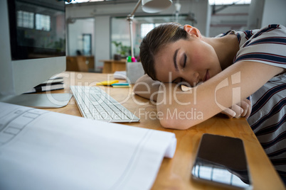 Overworked graphic designer sleeping on his desk