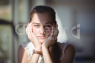 Pretty schoolgirl sitting in classroom