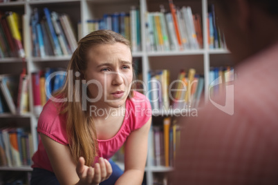 Student interacting with teacher in library