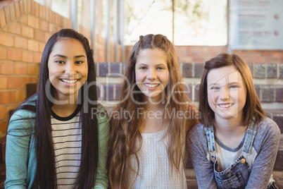 Portrait of smiling schoolgirls sitting on the staircase