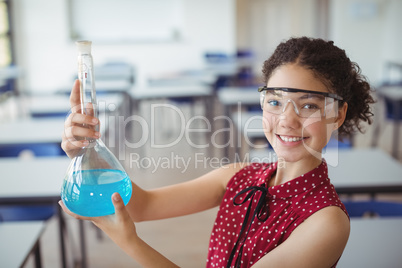 Portrait of smiling schoolgirl doing a chemical experiment in laboratory