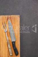 Knife and fork against wooden background