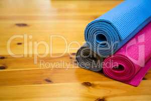 Rolled-up exercise mat on wooden floor