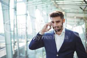 Businessman talking on mobile phone at railway station