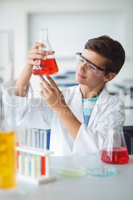 Attentive schoolboy doing a chemical experiment in laboratory