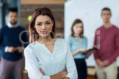 Business executive standing with arms crossed in office