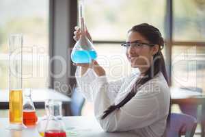 Portrait of happy schoolgirl doing a chemical experiment in laboratory