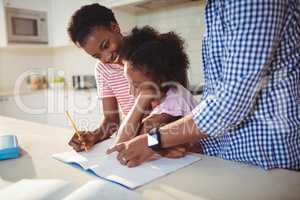 Parents assisting daughter with homework