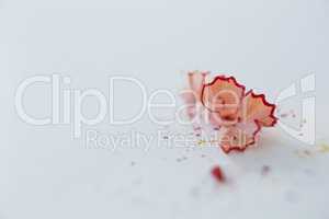 Red color pencils shavings on a white background
