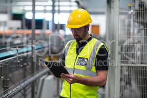 Factory worker using a digital tablet