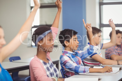 Student raising hand in classroom