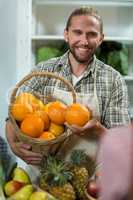 Smiling vendor offering oranges at the counter