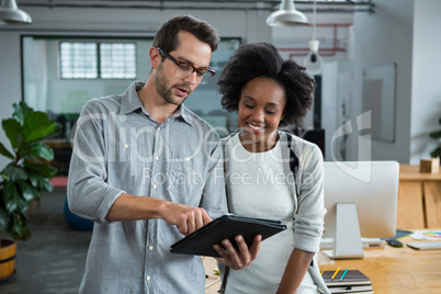 Man and woman discussing over digital laptop