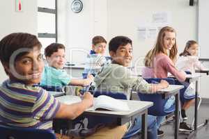 School kids doing homework in classroom at school