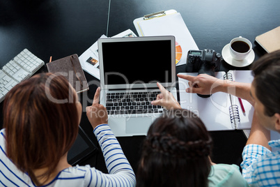 Graphic designers  discussing over laptop