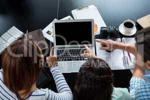 Graphic designers  discussing over laptop