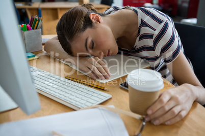 Overworked graphic designer sleeping on his desk