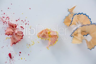 Colored pencils shavings on white background