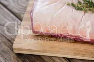 Beef brisket and herb on wooden tray against wooden background