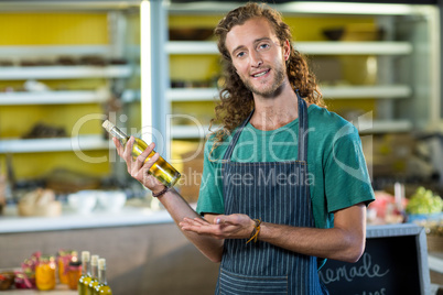 Shop assistant showing a bottle of olive oil