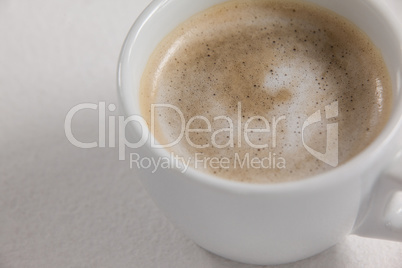 Close-up of white coffee cup with creamy froth
