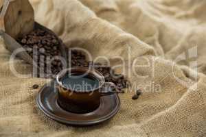 Black coffee, roasted beans and scoop on sack