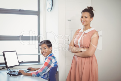 Portrait of smiling schoolboy using computer