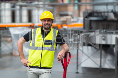 Factory worker standing with hand on hip in factory