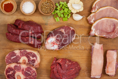 Varieties of meat with spices on wooden board