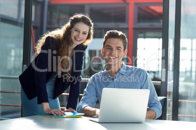 Businesspeople having discussion over laptop in office