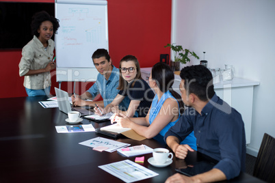 Business executives discussing over flip chart during meeting