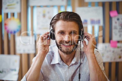 Close-up of male graphic designer listening music on headphone