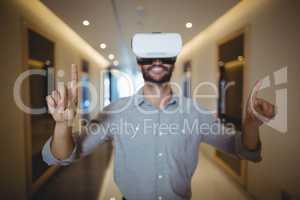 Male executive using virtual reality headset in corridor