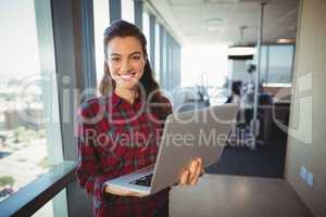 Female business executive holding laptop