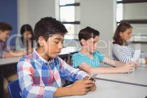 Students with digital tablet and mobile phone in classroom