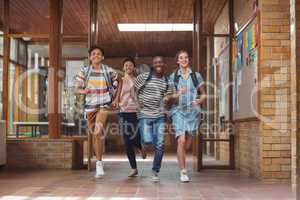 Excited classmates running in corridor