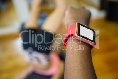 Womans hand using smart watch while workout in fitness studio