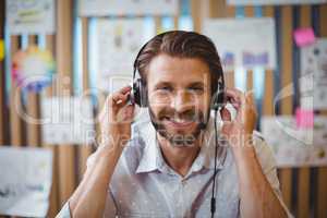 Close-up of male graphic designer listening music on headphone