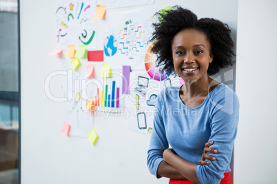 Female graphic designer standing with hands crossed in creative office