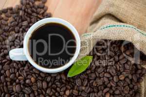 Coffee cup with coffee beans and coffee leaf