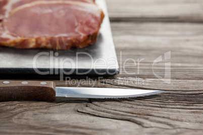 Sirloin chop on black slate plate with knife