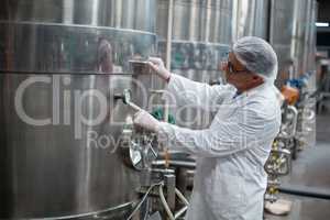 Factory engineer monitoring a pressure gauge of storage tank