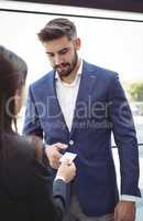 Businesswoman giving visiting card to businessman