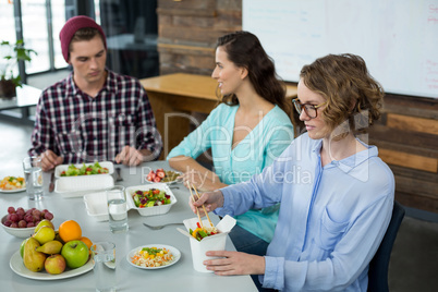 Smiling business executives having meal in office