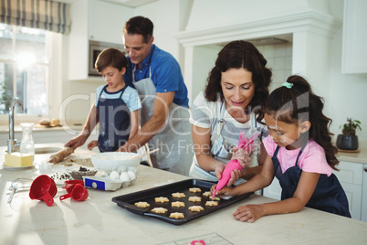 Happy family preparing cookies in kitchen