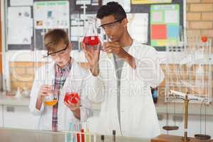 Attentive schoolboys doing a chemical experiment in laboratory