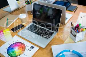 Laptop, color swatch and mobile phone on desk